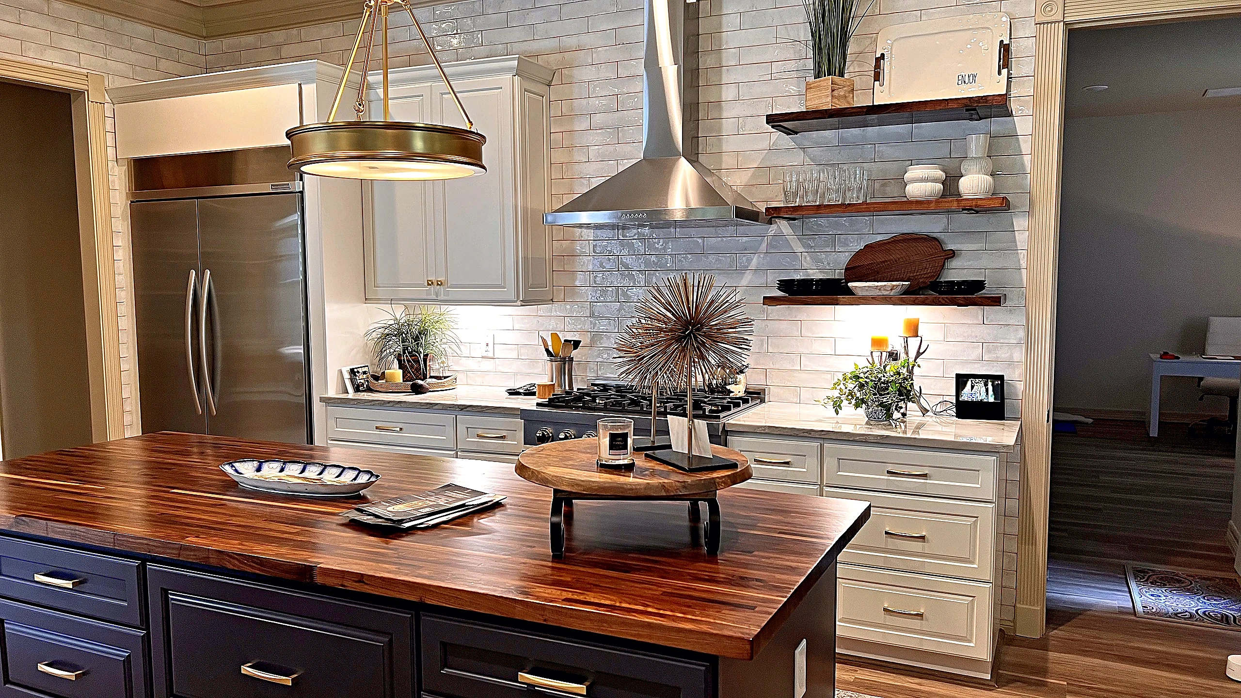 Navy island with brass hardware and butcher-block top — Bager full-home remodel in Tomball TX