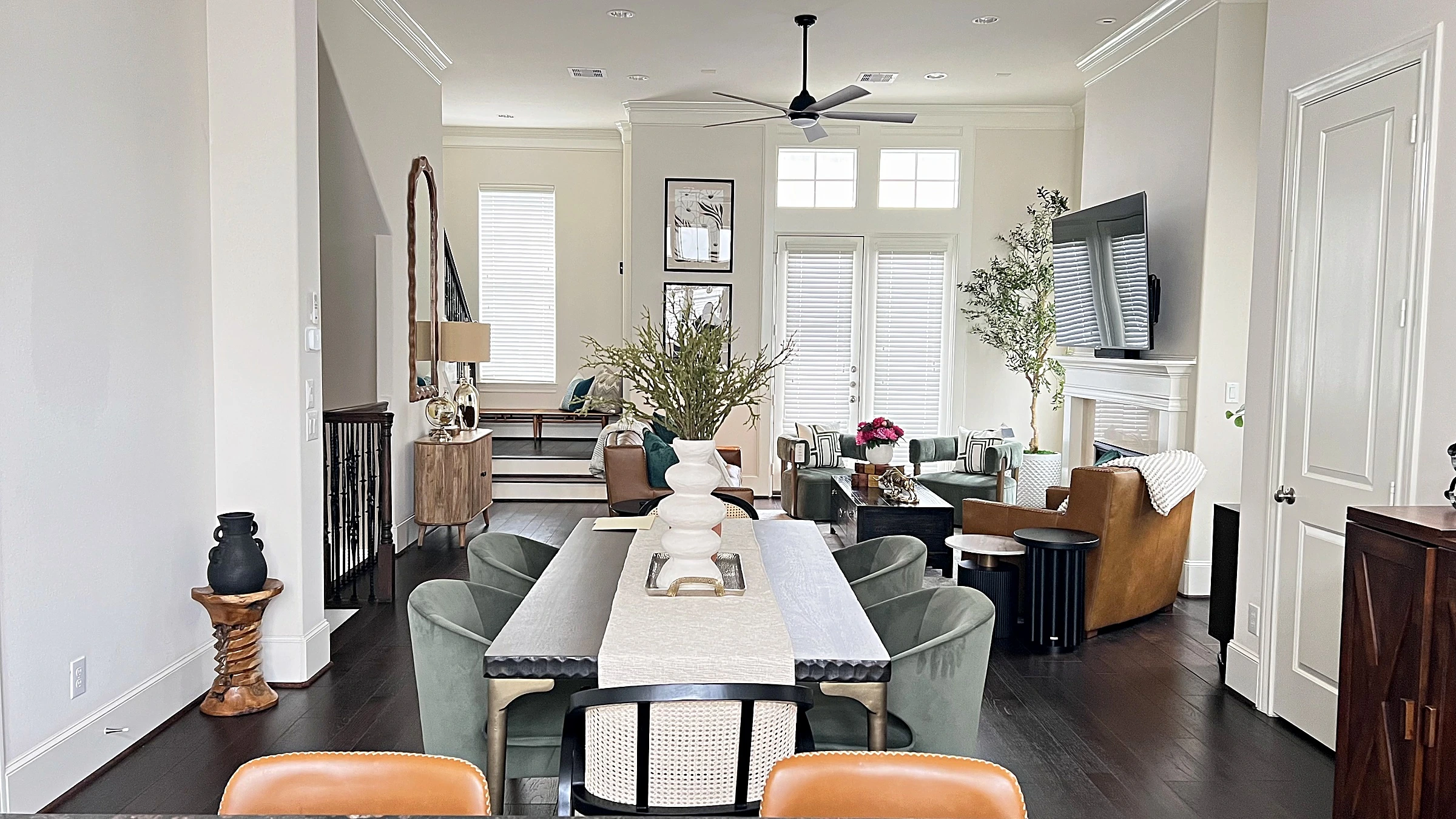 Open living and dining area with a table and chairs beside the fireplace in a West University Place townhome, Houston