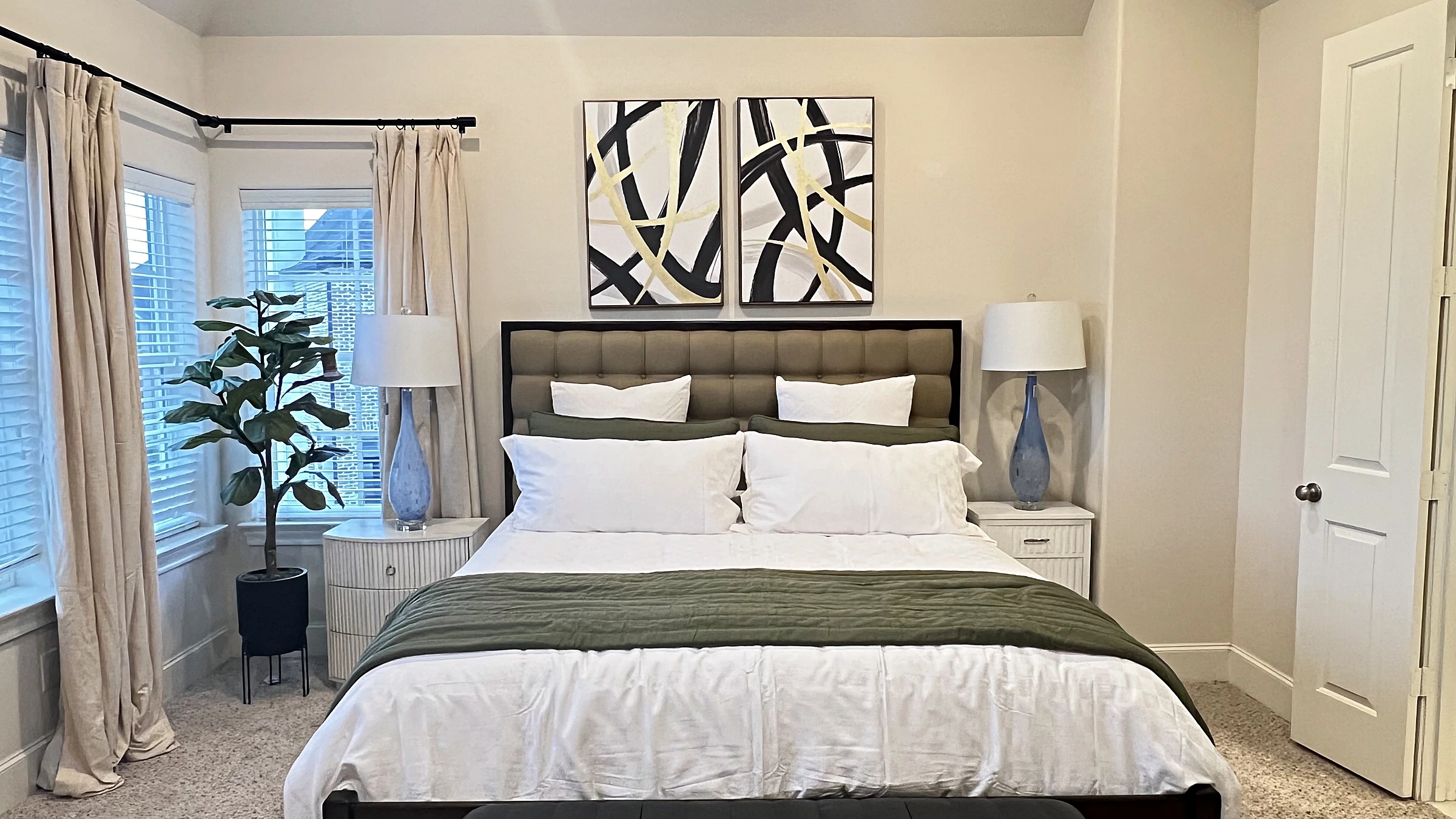 Primary bedroom with an upholstered bed, paired nightstands and lamps, and framed abstract art above the headboard, West University Place